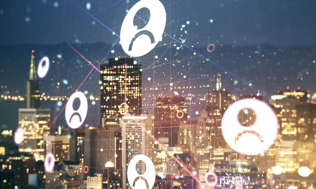 Leuchtende Personensymbole und digitale Verbindungslinien über einer nächtlichen Skyline mit beleuchteten Hochhäusern.